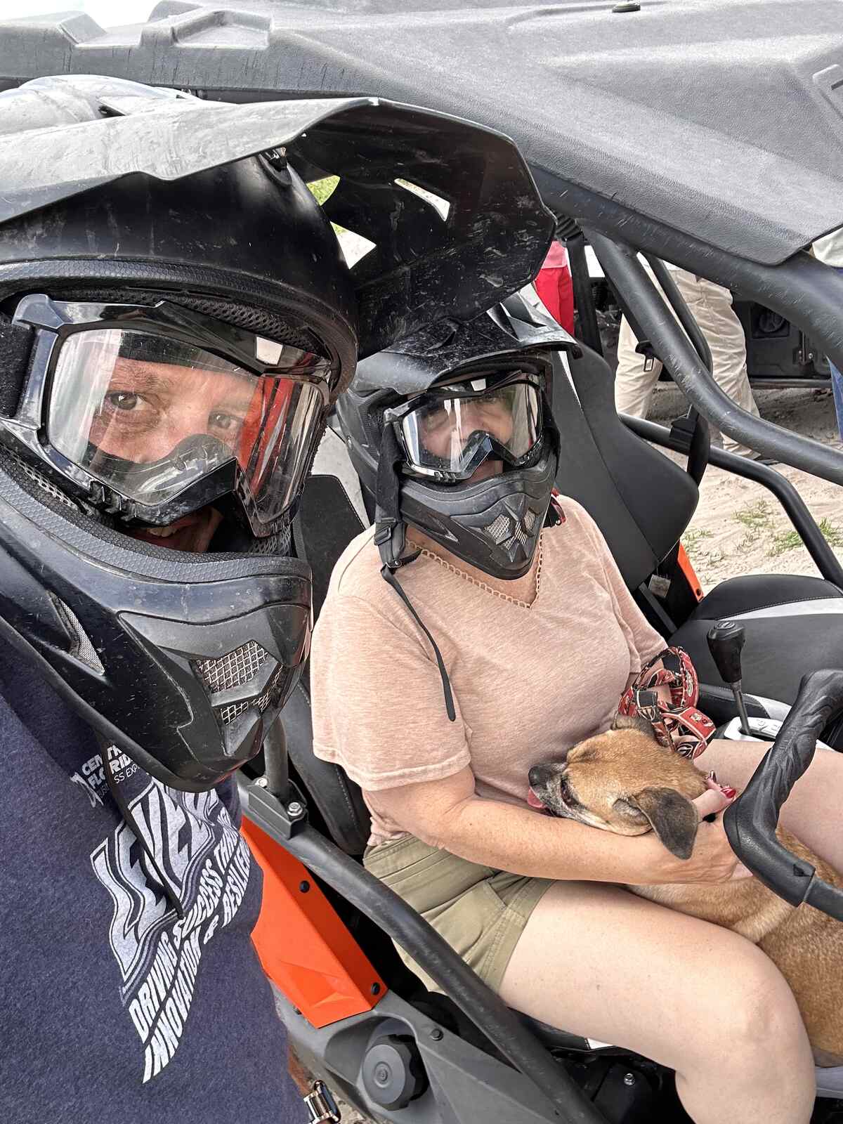 Jim and Angie in helmets in the rented side-by-side with their dog at Peace River Oaks, Bowling Green, Florida