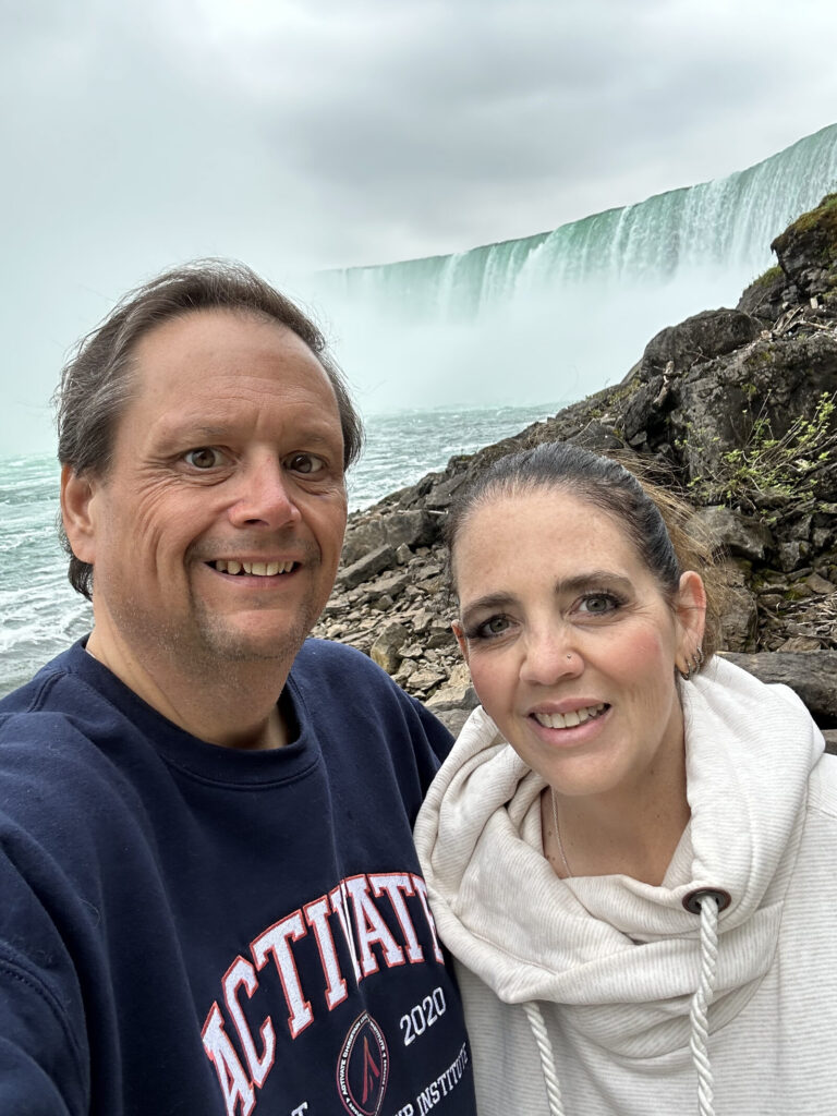Jim and Angie Mosier smiling in front of Horseshoe Falls at Niagara, June 2025